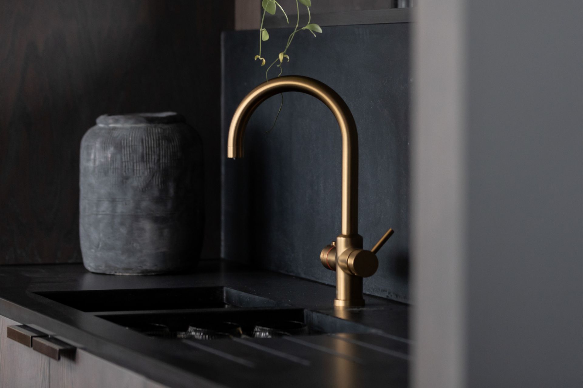 Dark grey kitchen wit gold tap