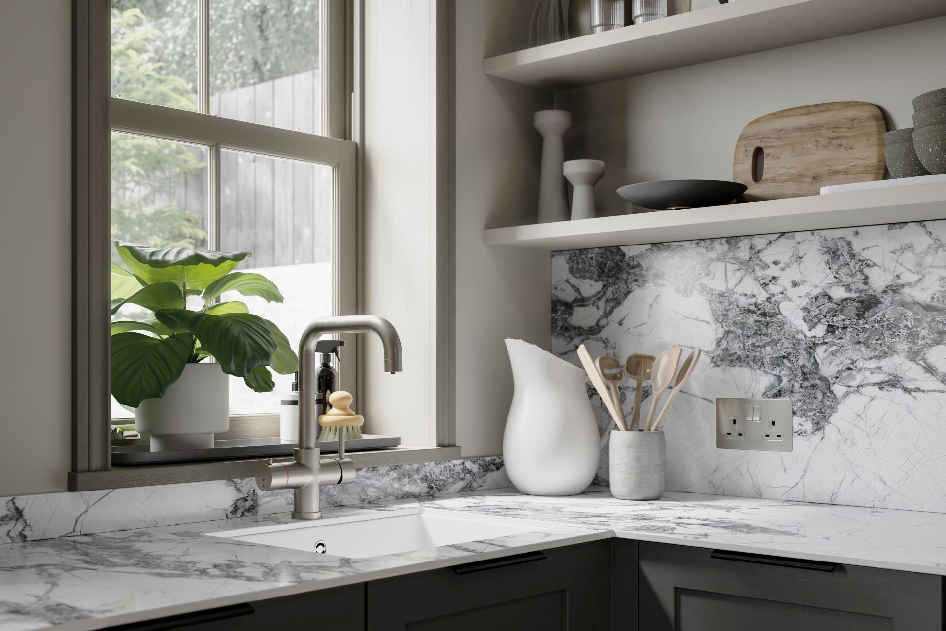 Kitche with white marble counters and splashback, silver hardare, and dark grey cabinets