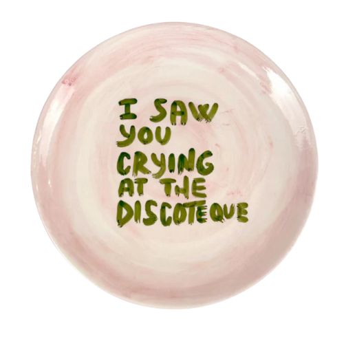 Pink dish with green writing that reads 'I saw you crying at the discoteque'