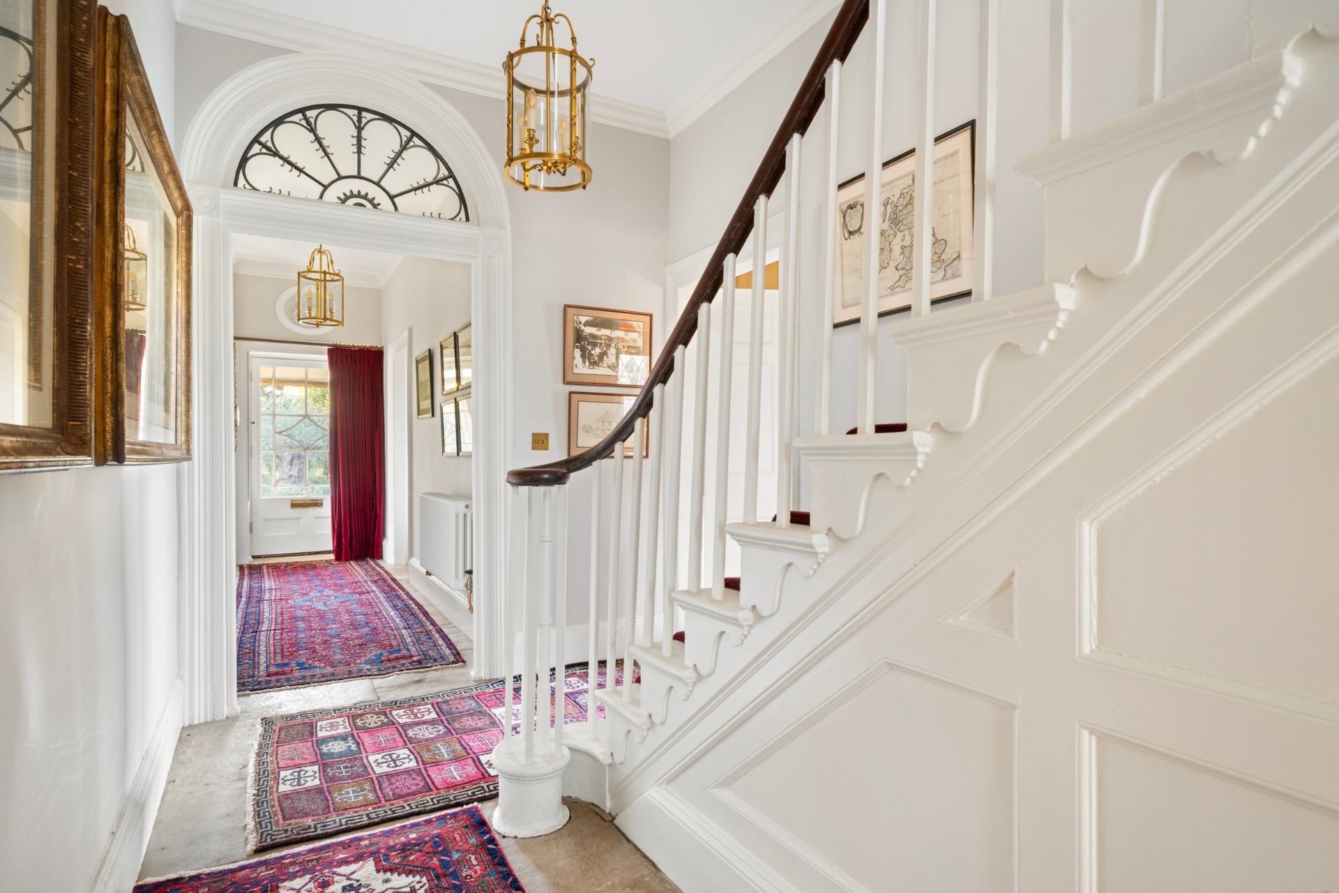 White hallway with domed window and gold accents