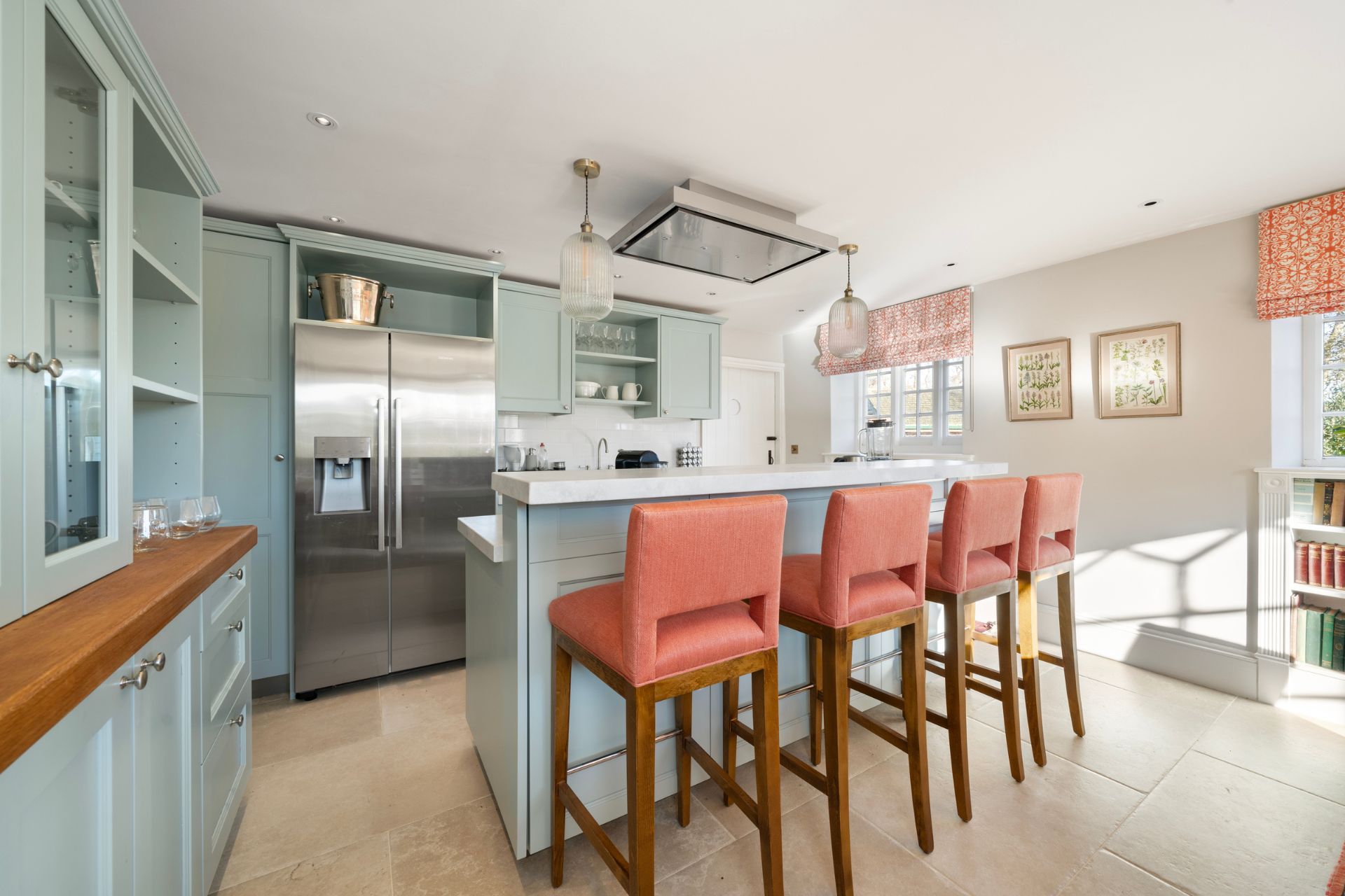 Modern kitchen with pale blue cabinets and light red barstools