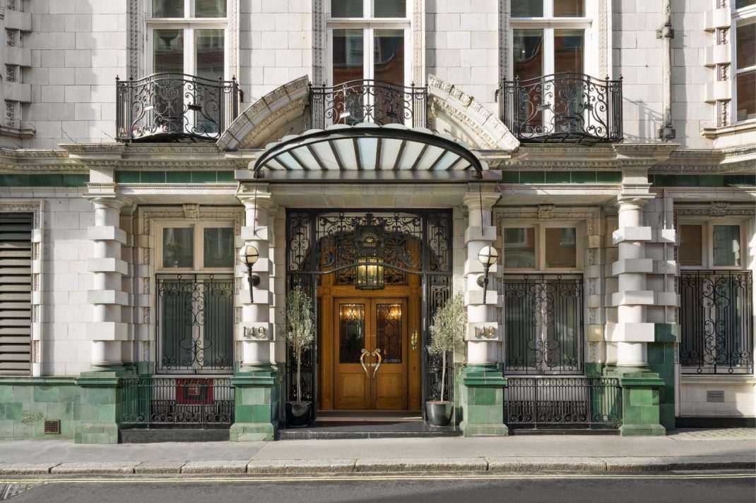 Exterior of Mayfair Art Nouveau building with sash windows and a wooden door