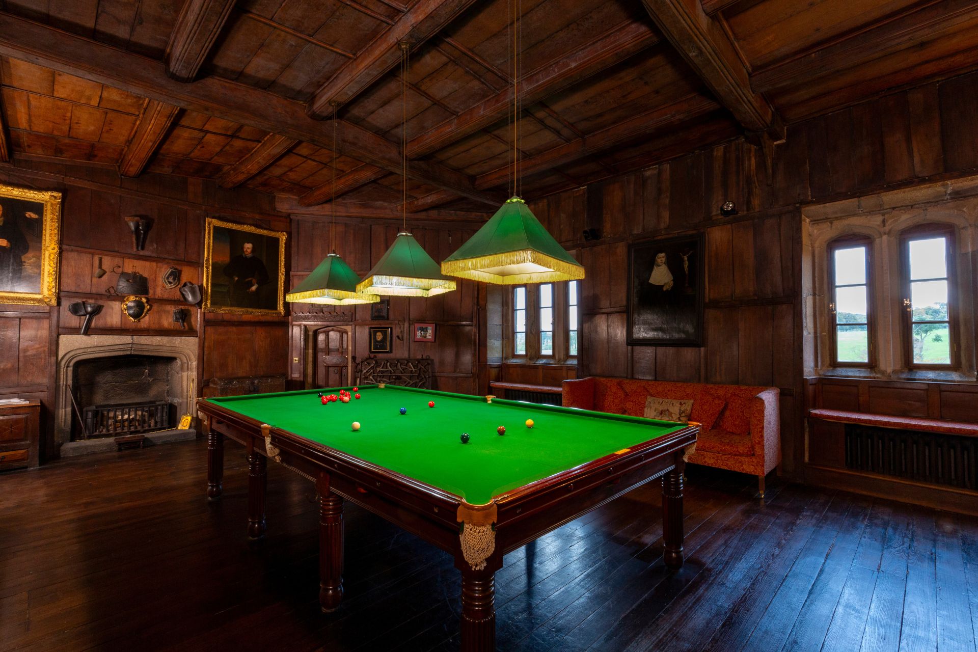 Billiard room with green lamps and panelled ceilings