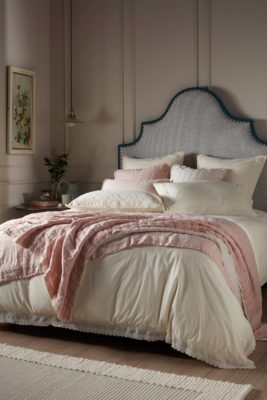 Cream panelled bedroom with blue fabric headboard