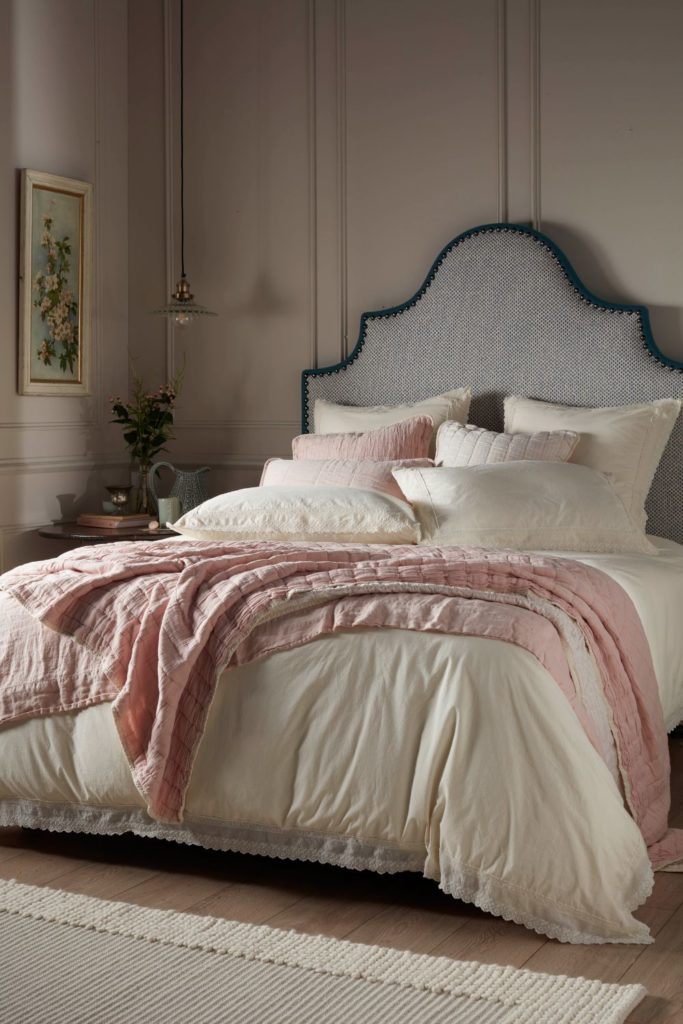 Cream panelled bedroom with blue fabric headboard