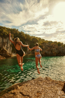 A mother and daughter jumping into the sea