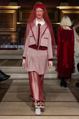 Woman in red veil and skirt suit walking runway for Bora Aksu AW25
