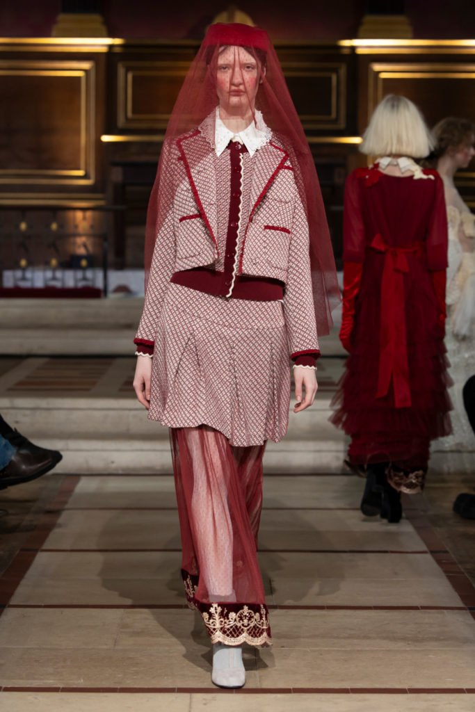 Woman in red veil and skirt suit walking runway for Bora Aksu AW25