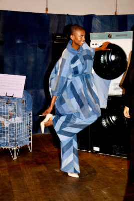 Model in denim outfit stood by washing machine
