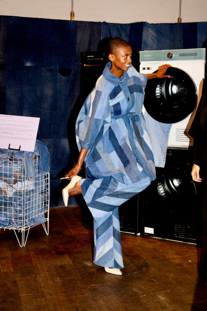 Model in denim outfit stood by washing machine