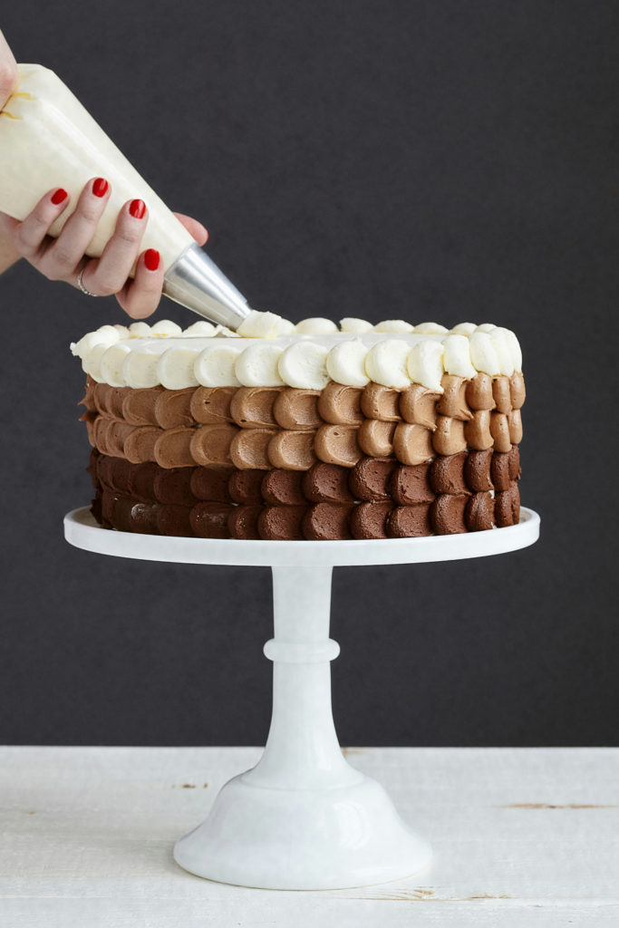 A person icing a cake