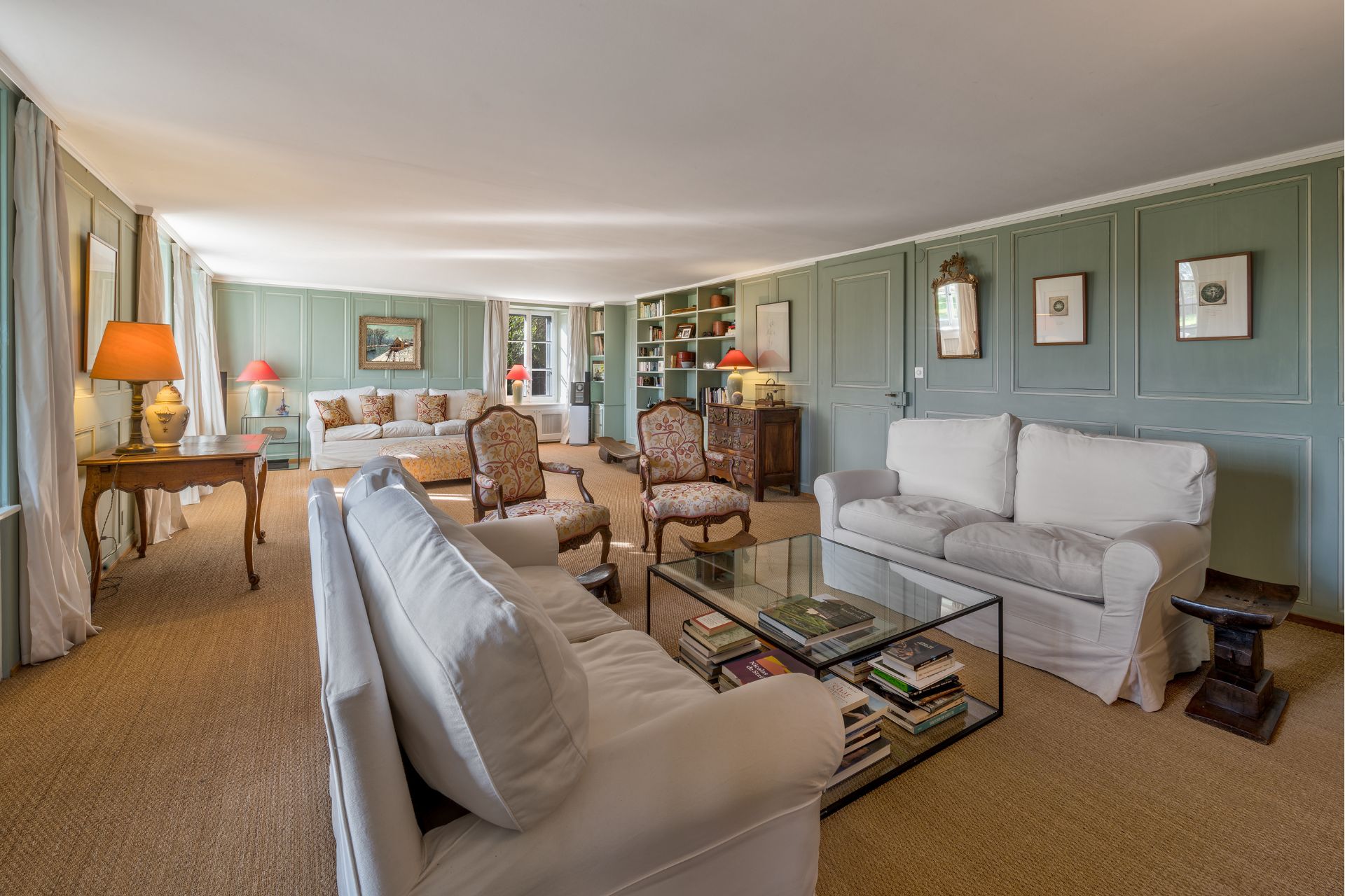 Living room with a jute rug, cream sofas and pale blue panelled walls.