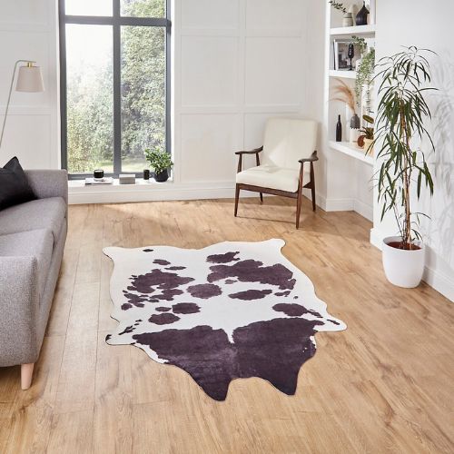 Faux cow print rug on a pale wooden floor