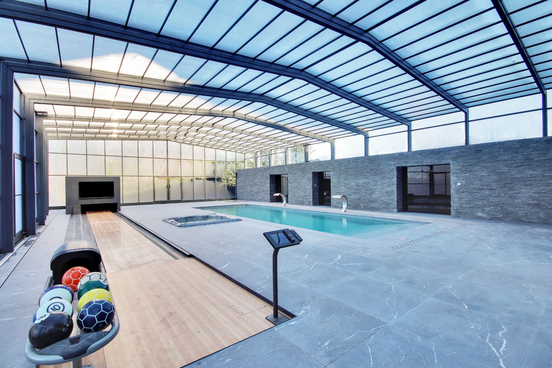 Glass-ceilinged swimming pool complex with a bowling alley