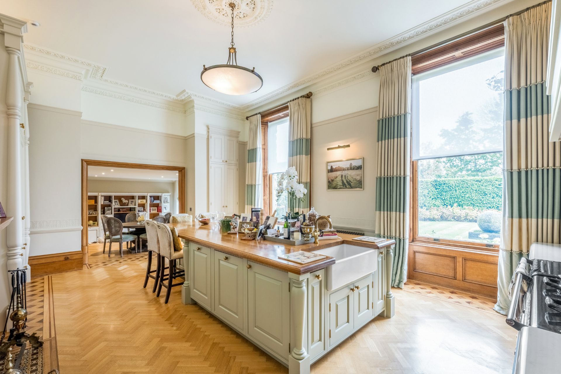 Large kitchen/dining room with oak herringone flooring and a shaker-style island with a built-in sink