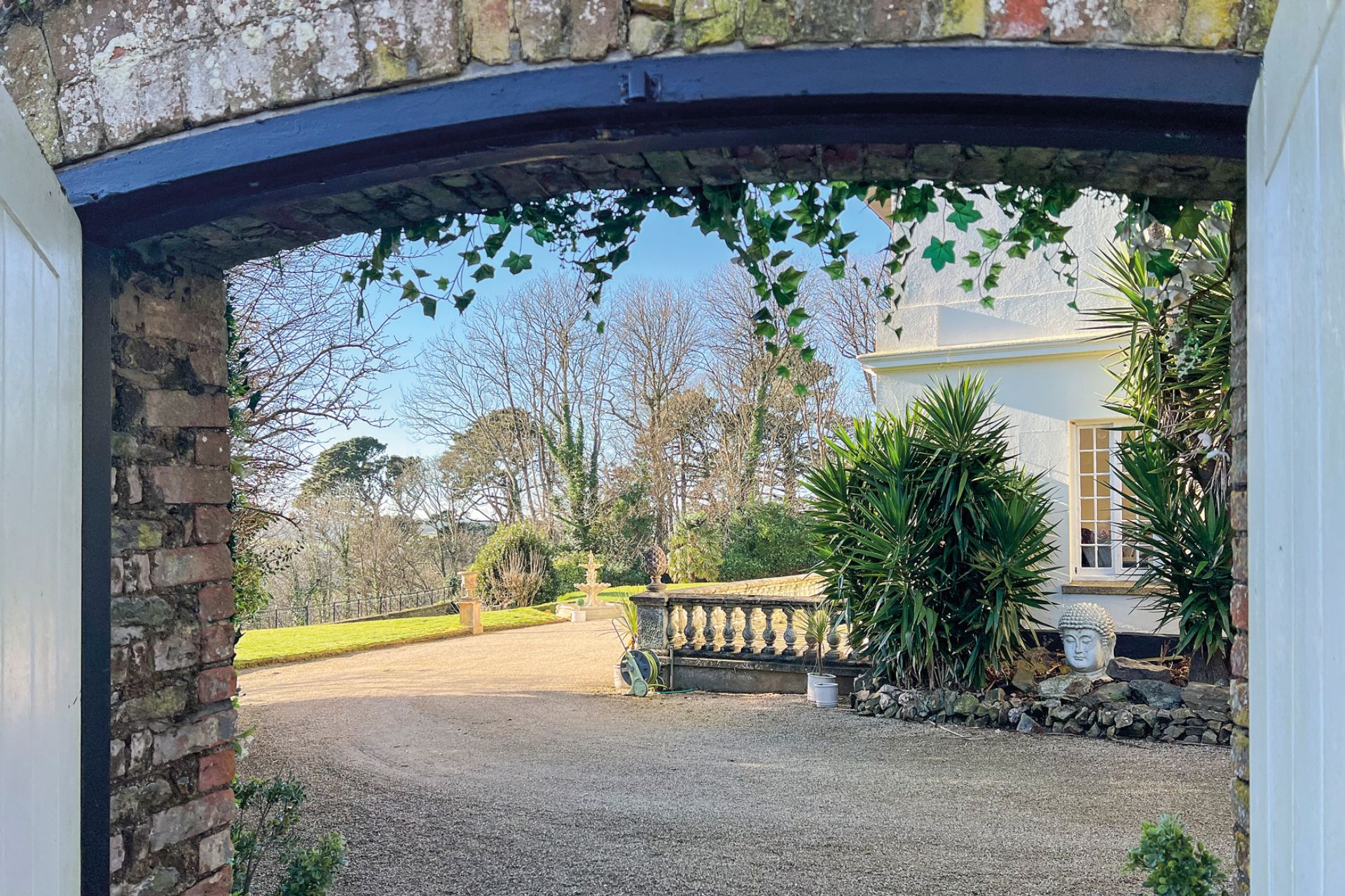 Large garden with a gravel driveway and sweeping lawns.