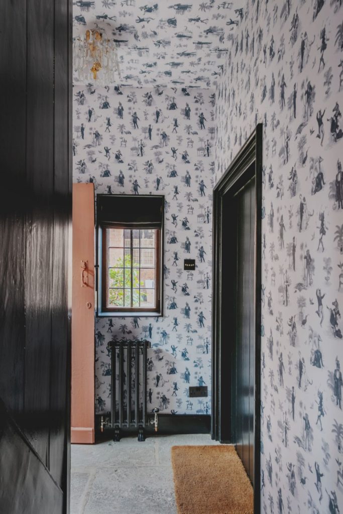 Hallway with blue and white floral wallpaper on the walls and ceiling.