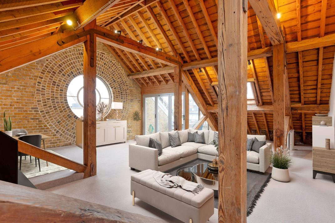 Penthouse living room with wooden vaulted ceiling, wooden beams, and an exposed brick wall with a circular window