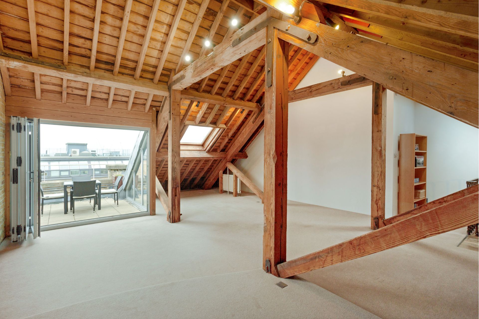 Penthouse with wooden vaulted ceiling, exposed beams and a roof terrace