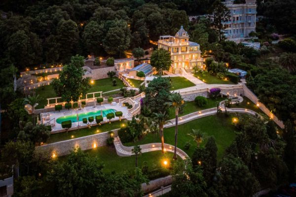 Aerial view of villa on the French Riviera, with an outdoor pool, landscaped gardens and large terraces.