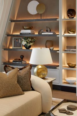 Backlit shelves with gold and cream accessories including books, vases and paperweigts
