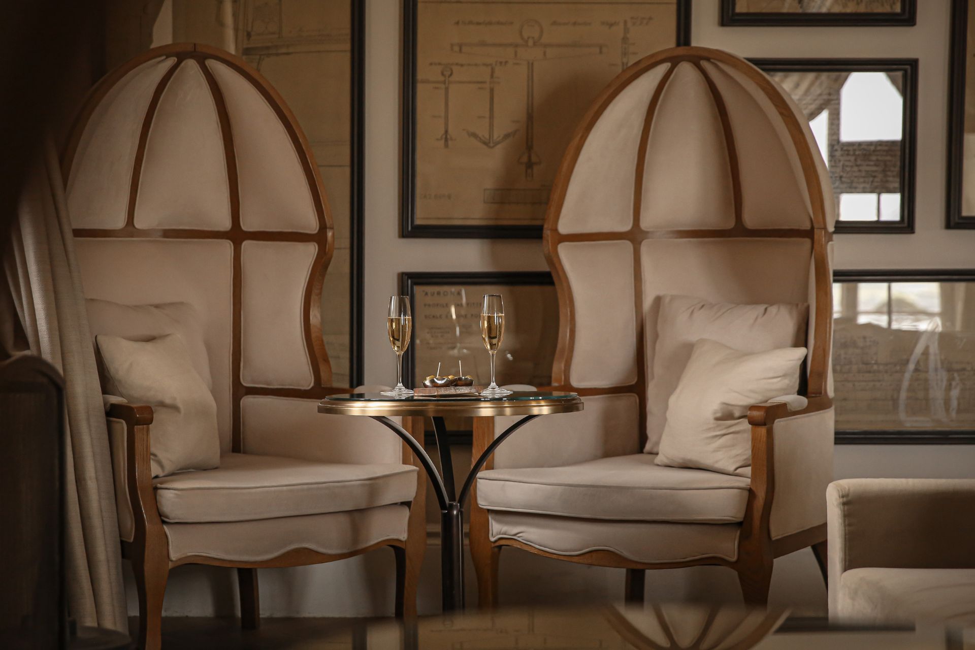 DIning room with large, cream canopy chairs and gold accents