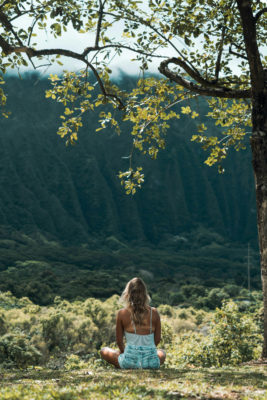 A calm woman meditating surrounded by nature