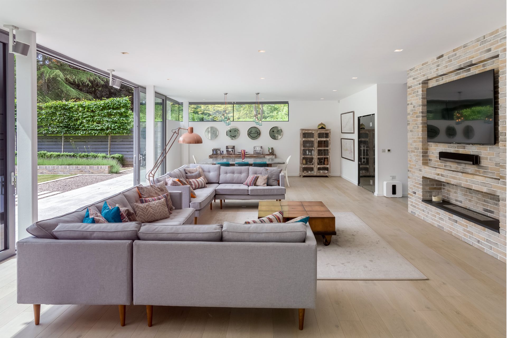 Living room with beige modular sofa, cream carpet and floor-to-ceiling windows