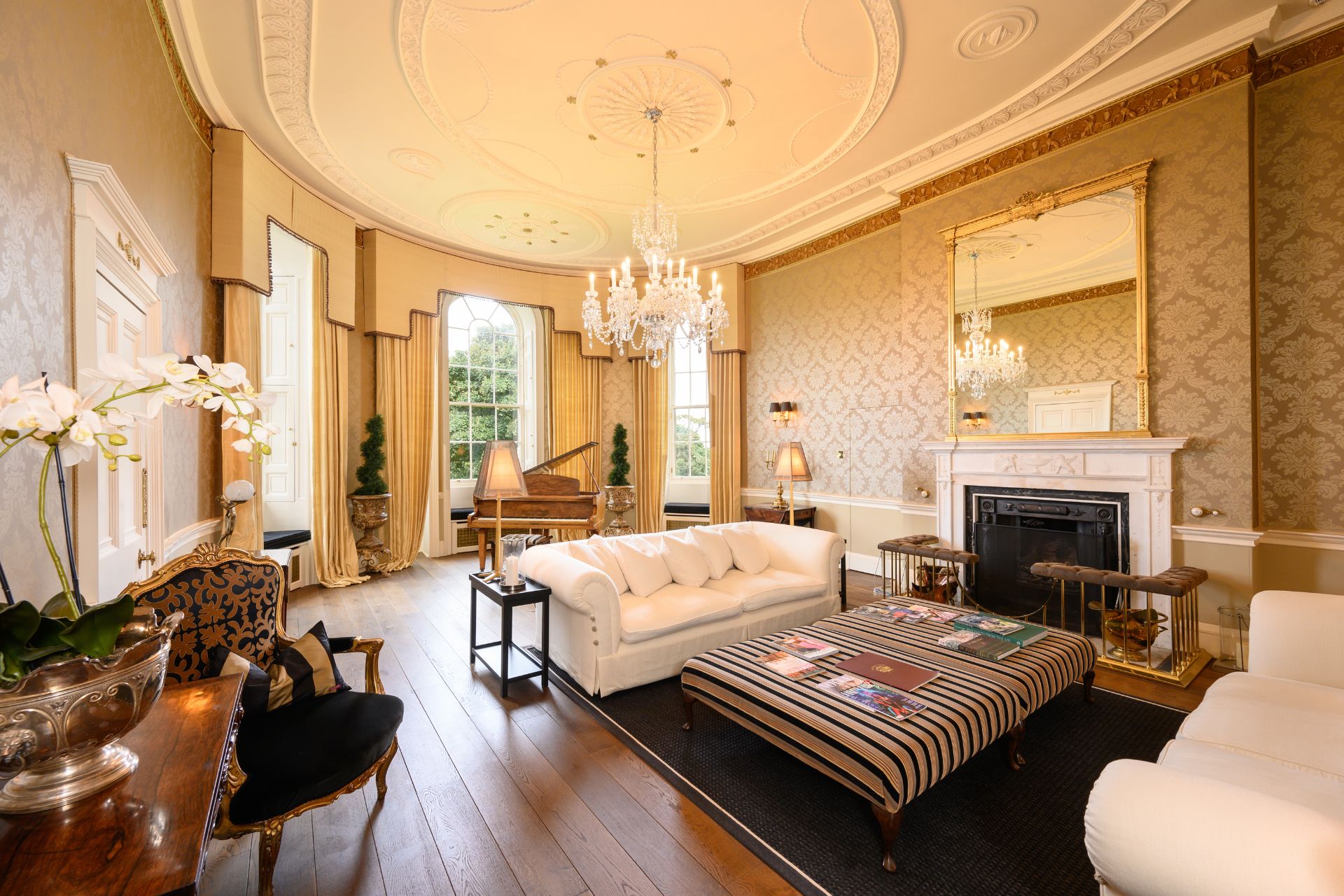 Castle living room with intricate ceiling plasterwork, oak floors and a crystal chandelier