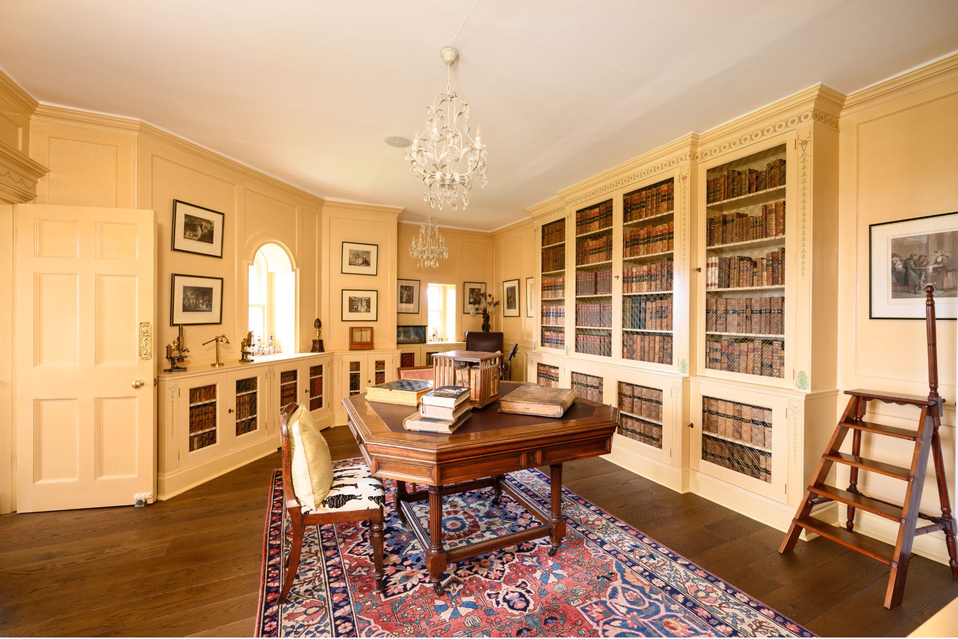 Castle study with oak floors, arched windows and built-in bookcases