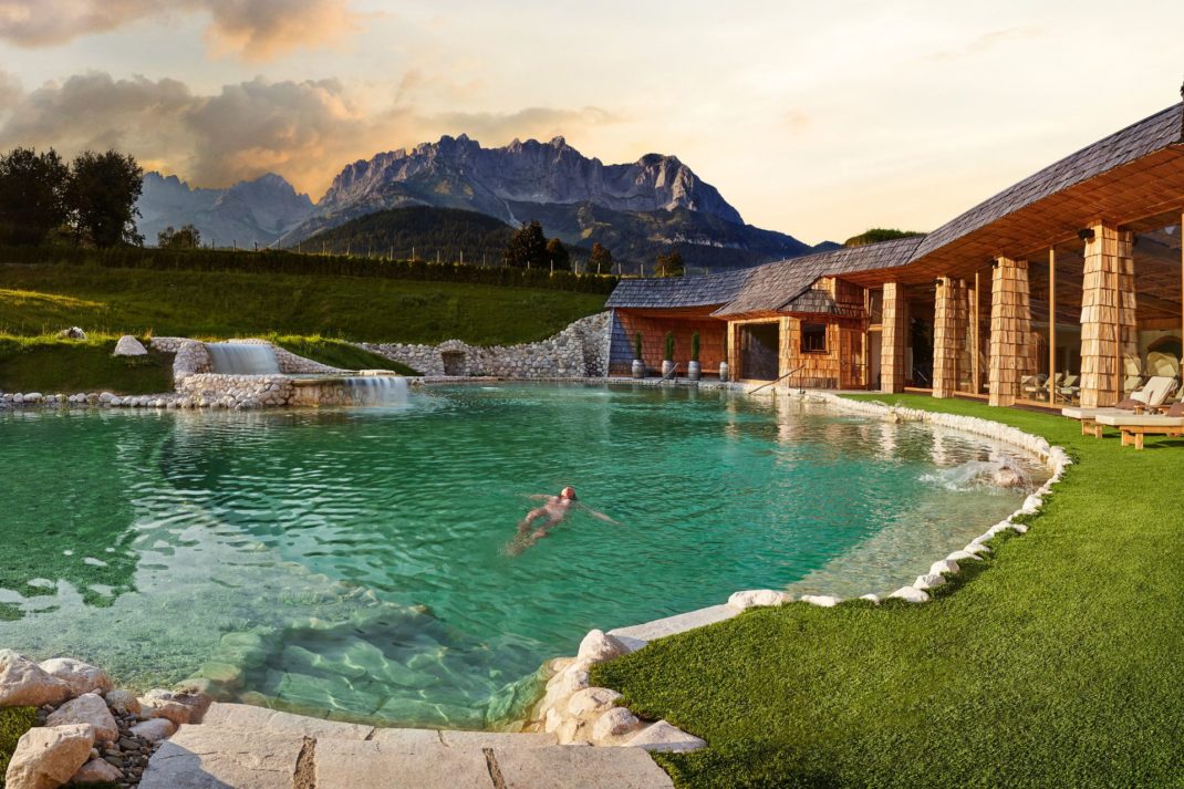 Outdoor swimming pool and spa at Stanglwirt, in view of the mountains.