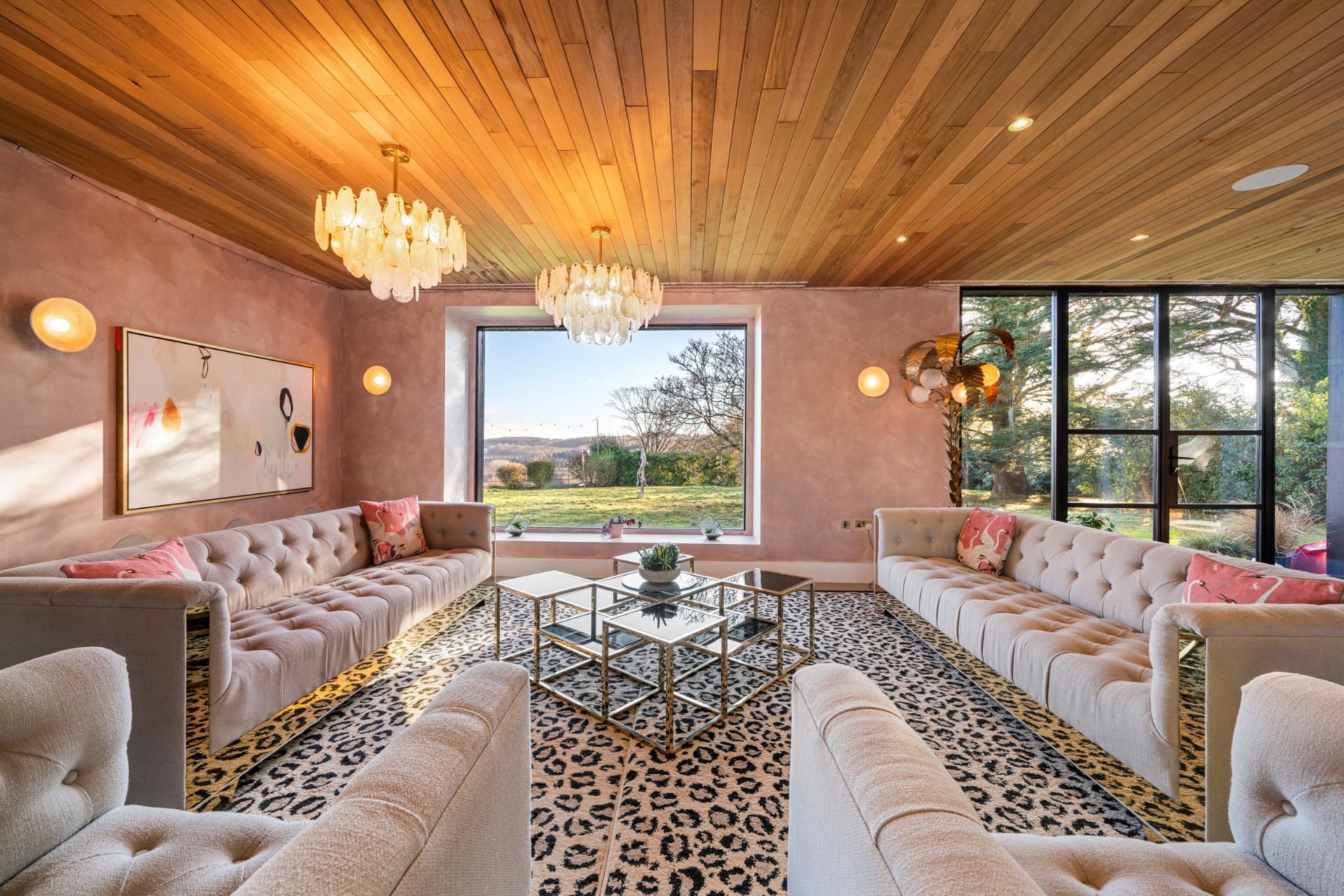 Leopard-print living room with wood panelled ceiling and pale pink walls