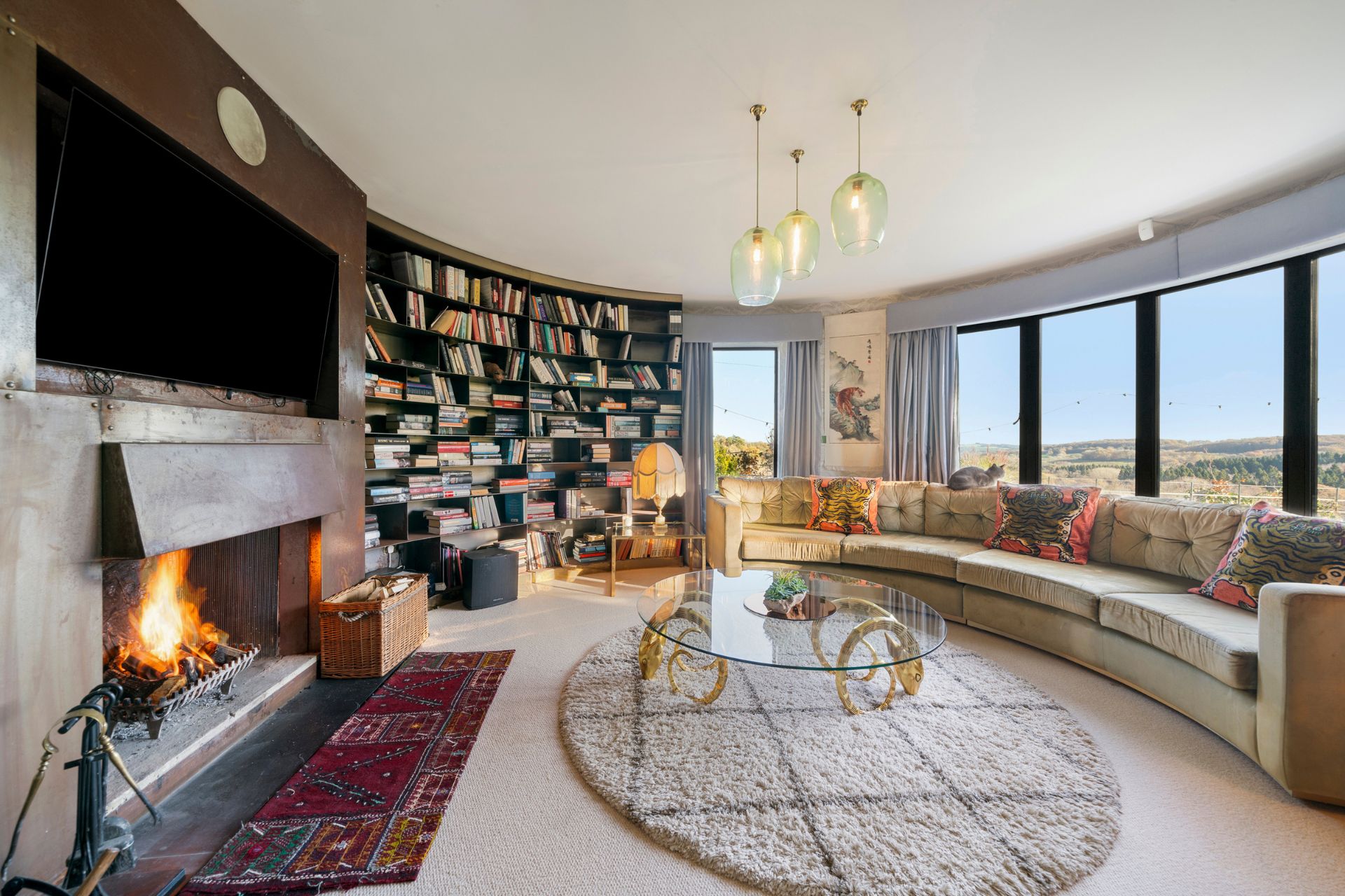 Circular living room with built-in bookshelves and countryside views