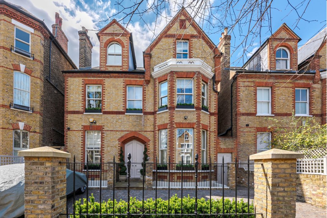 Exterior of gated, red brick home in Clapham North