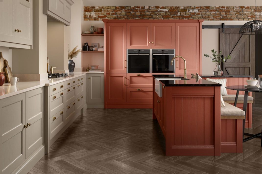 Kitchen with pale taupe cabinets and a peach-pink wall unit with a built-in oven.