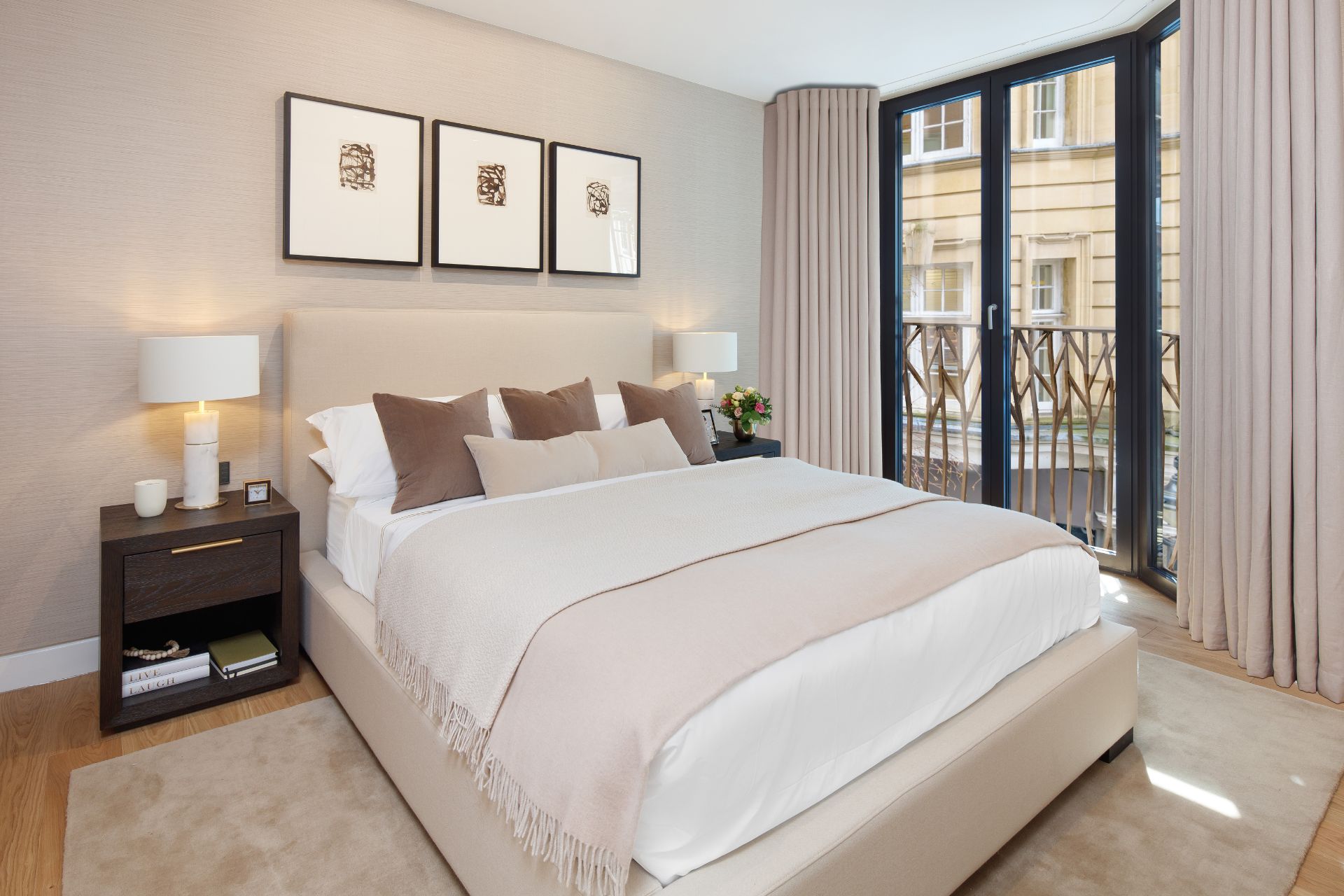 Bedroom with cream walls, matching curtains and bedding, and floor-to-ceiling windows.