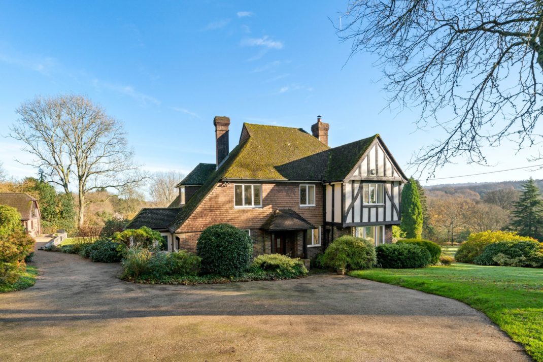 Exterior of 1930s cottage with landscaped gardens and large driveway