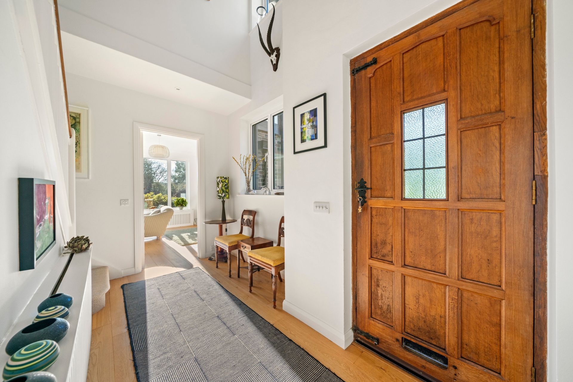 Hallway with large oak door and grey rug