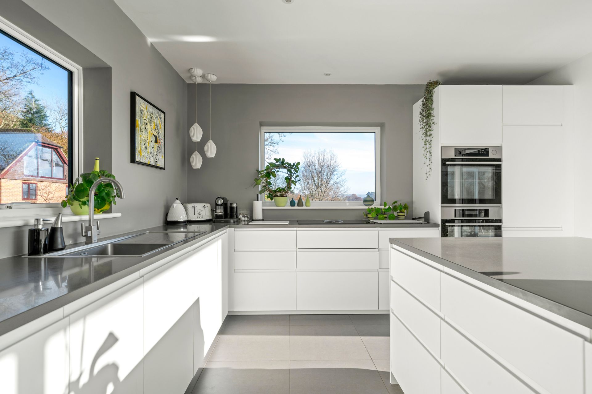 Kitchen with sleek white cabinets, grey worktops and grey walls