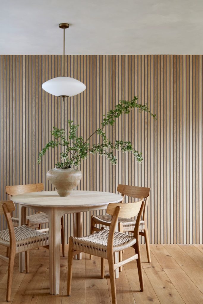 Wood-panelled dining area with wooden floors and pale wooden furniture.