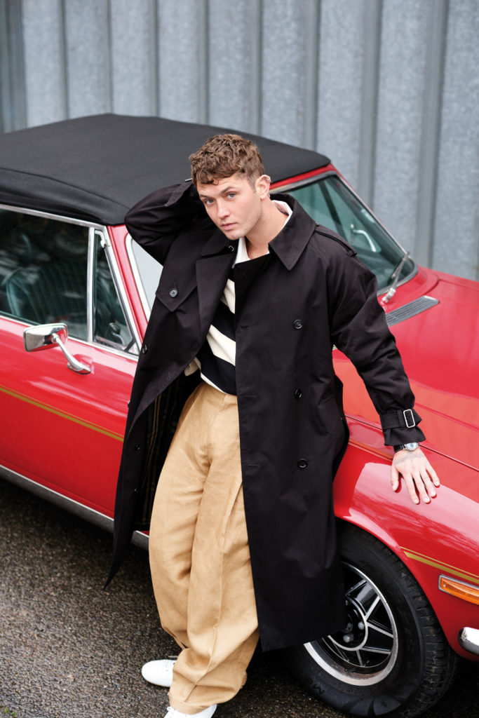 Rafferty Law standing beside a red car
