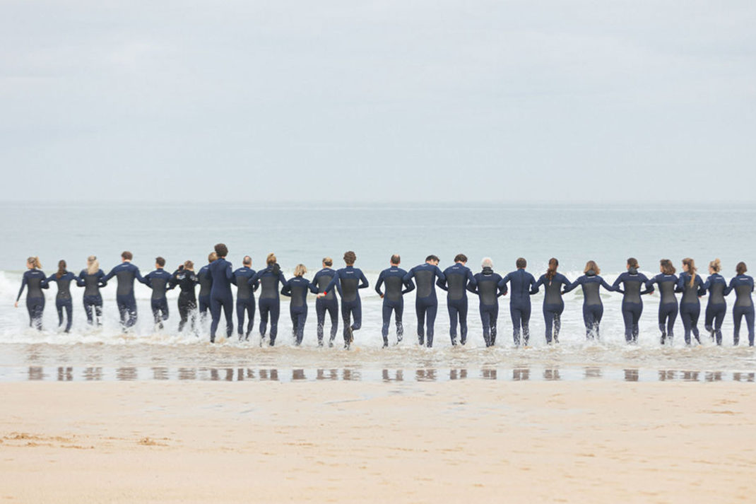 Group of people running into the sea