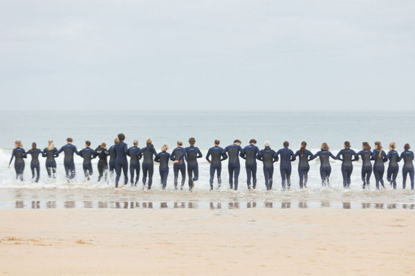 Group of people running into the sea