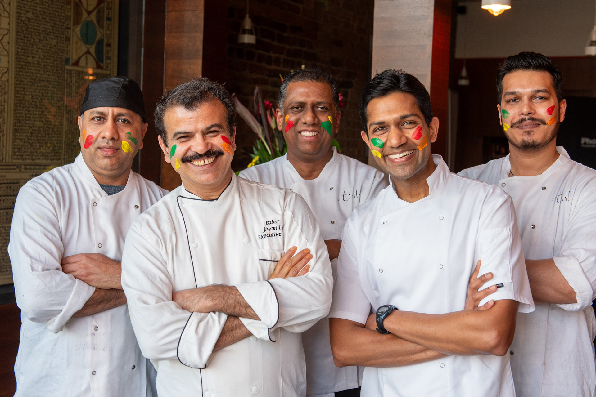 A group of chefs with coloured paint on their faces