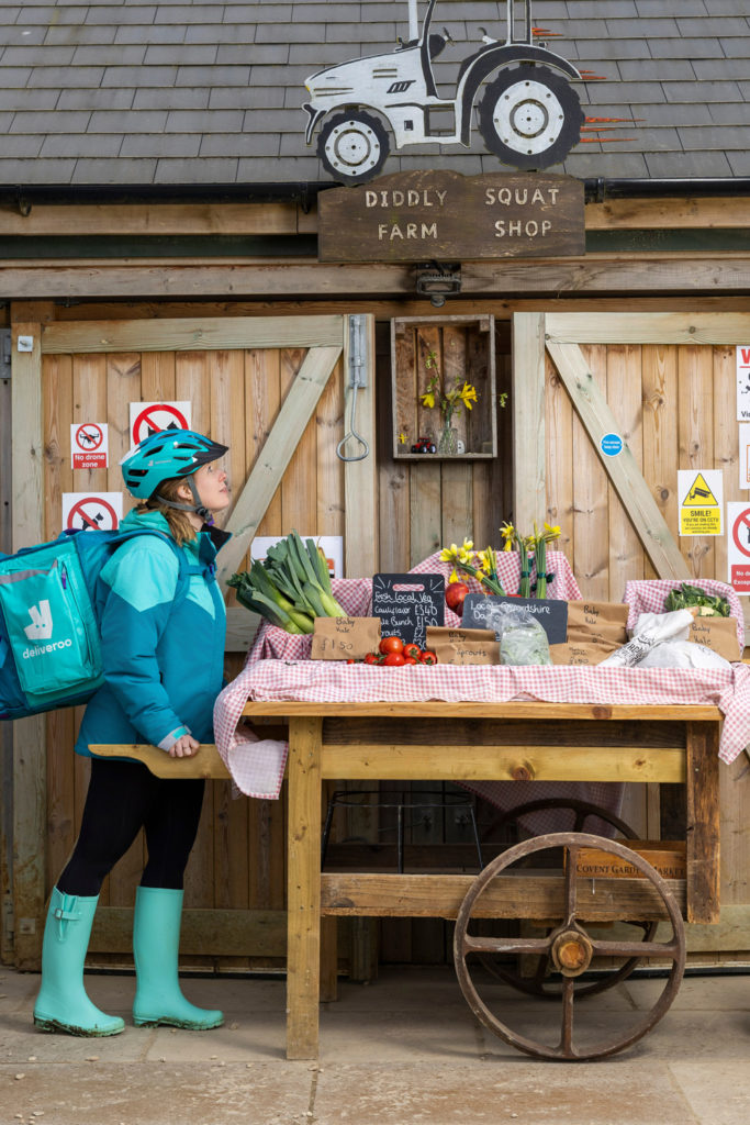 Deliveroo driver standing outside Diddly Squat Farm Shop