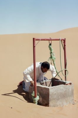 Man looking at the water level in the well