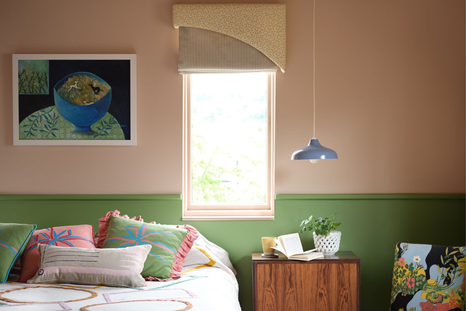 bedroom with pale pink walls, pistachio green panelling and a patchwork bedspread