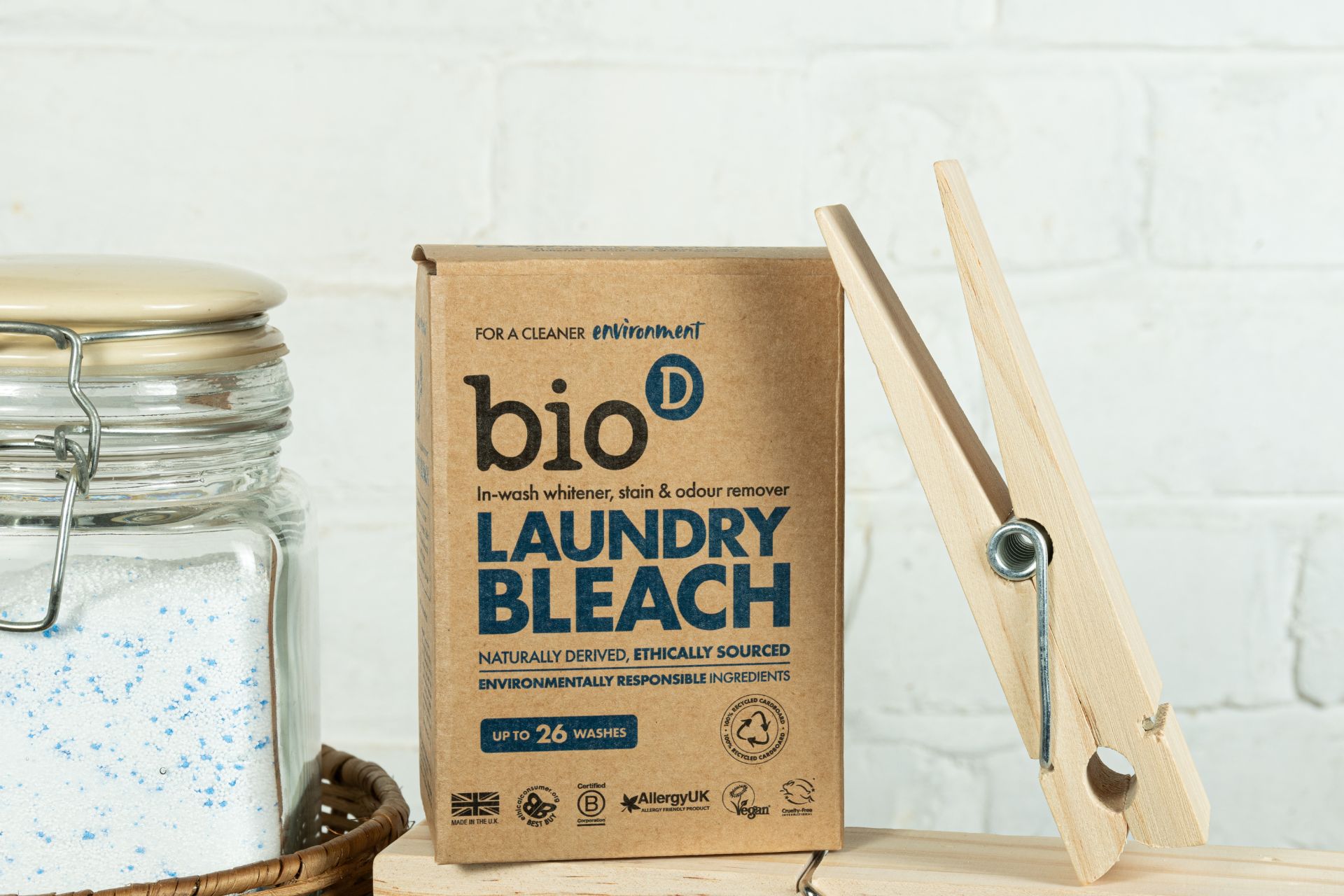Bio-D Laundry Bleach in a biodegradable box, with a clothes peg and a set of towels behind