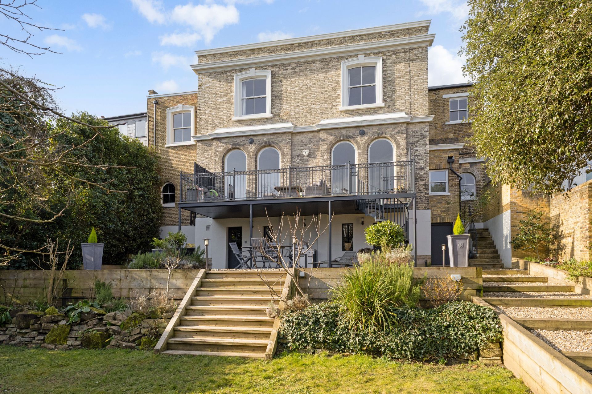 Rear garden of Crystal Palace house with tiered lawn, stone terrace and balcony