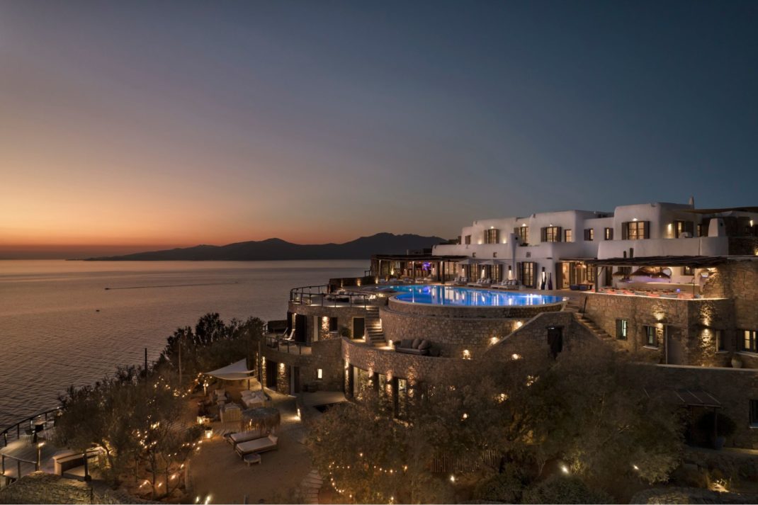 Dusk view of hilltop Greek mansion with infinity pool